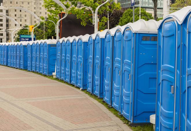 a row of portable restrooms at an outdoor special event, ready for use in Eastchester